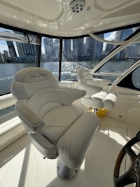 the interior of a boat with white seats and a view of the water