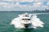 a motor boat traveling through the water with a city in the background