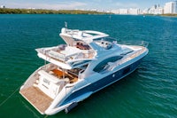 a motor yacht in the water with a city in the background