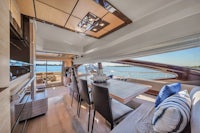 the interior of a yacht with a dining table and chairs