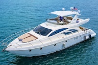 a white motor yacht in the ocean with two people on it