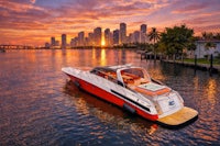 a speed boat on the water with a city skyline in the background