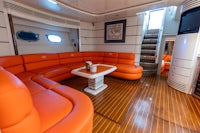 the interior of a boat with orange couches and a coffee table